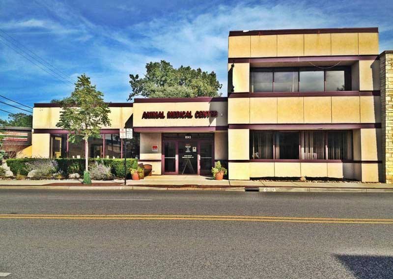 Animal Medical Center building with cream and maroon walls and a sign above the glass entrance