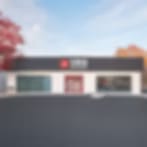 Very small blurry image of a single-storey building with a dark front and autumn-coloured trees