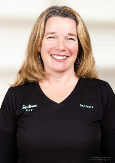 Smiling woman with shoulder-length blonde hair in a black top with Seatown Vet lettering