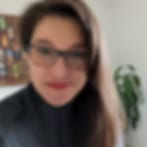 Small blurry portrait of a person with long dark hair, glasses and a dark top