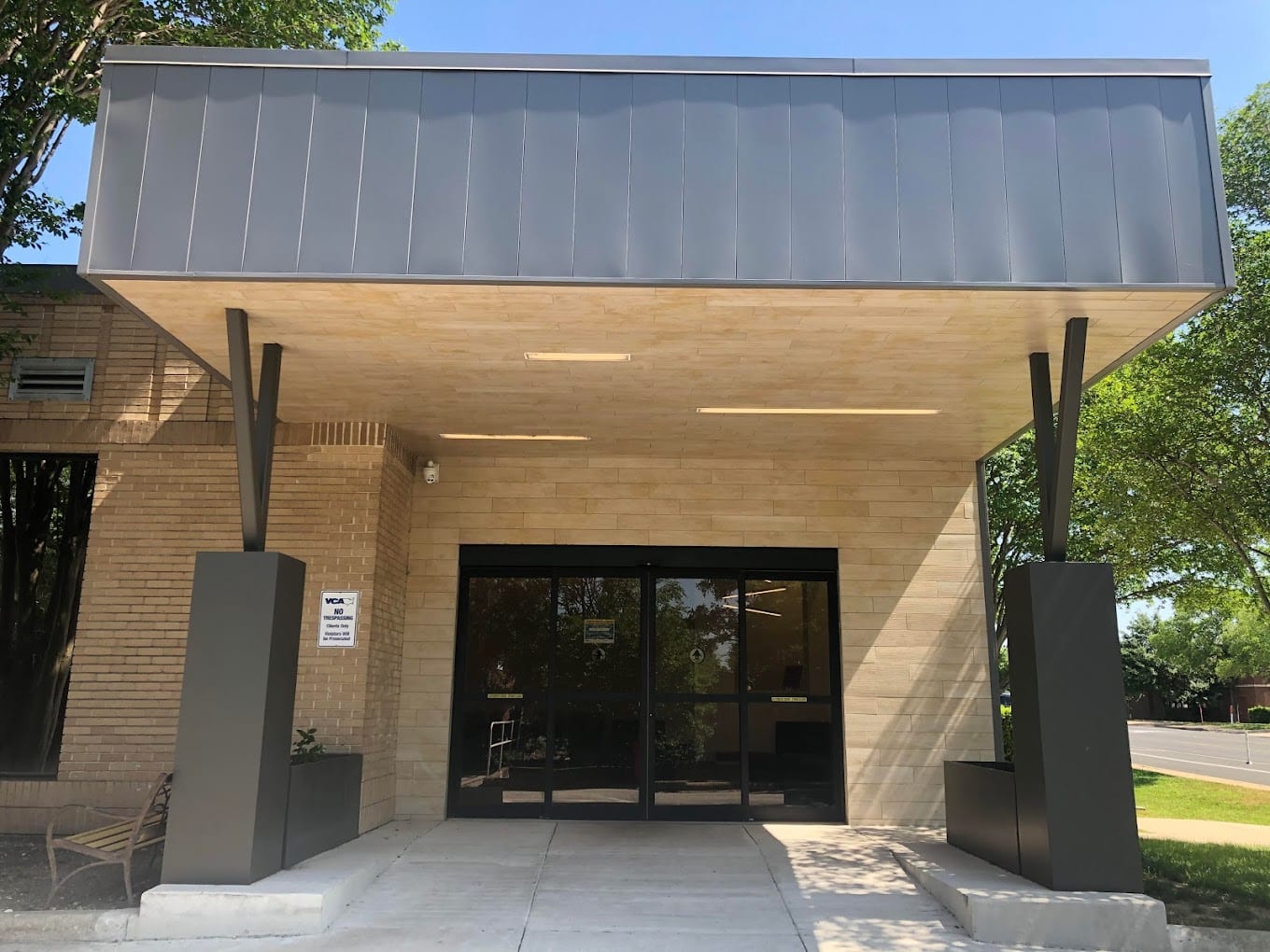 Covered entrance of CVCA Cardiac Care for Pets with a dark metal canopy, beige brick walls and glass double doors