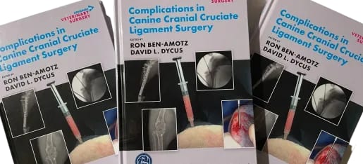 Three copies of a veterinary surgery book with a white cover showing X-ray images, a syringe and a surgical photo