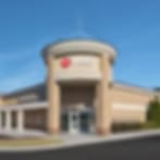 Small blurry photo of a tan building with a rounded entrance tower at VEG ER for Pets