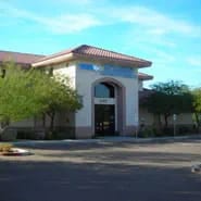 Low-resolution view of a tan building with a terracotta roof and an arched entrance