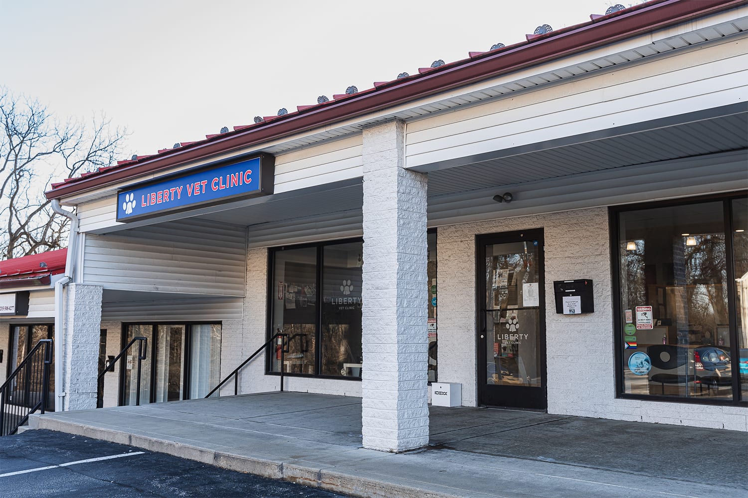 Liberty Vet Clinic storefront with a red roof edge, blue sign and white brick columns