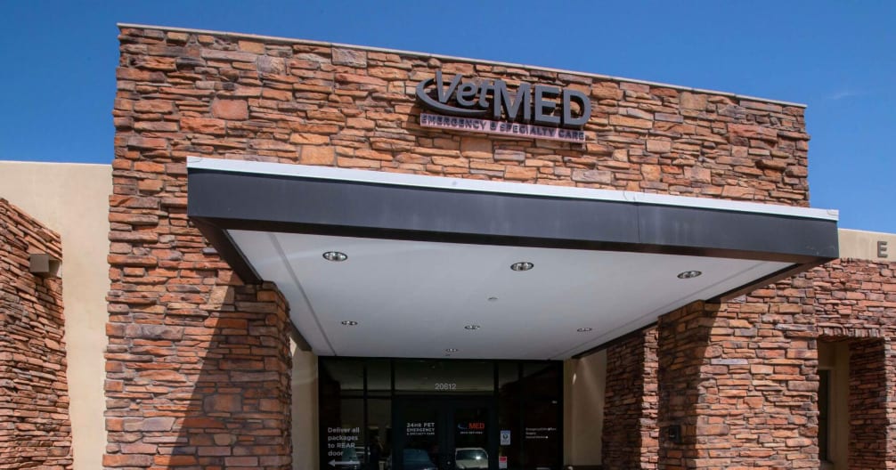 Stone-fronted building entrance with a covered canopy and a VetMED sign