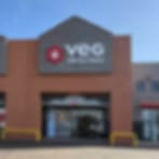 Blurry low-resolution photo of a red-brown storefront with a dark sign above glass doors