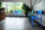 Blurry image of a room with blue chairs along a wall and a plant by a window at Kenwood Pet Clinic