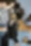 Very small blurry image with dark shapes and a beige area, details unclear