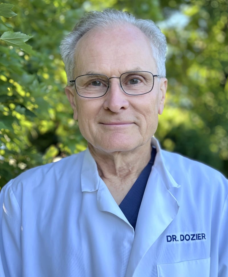 Rea Road Animal Hospital team portrait of an older man with gray hair and glasses in a white coat