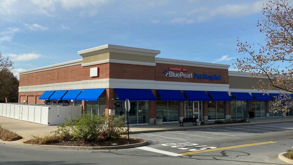 BluePearl Pet Hospital brick building with blue awnings seen from the corner of the lot