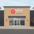 Very blurred storefront with a red logo above glass double doors on a beige building