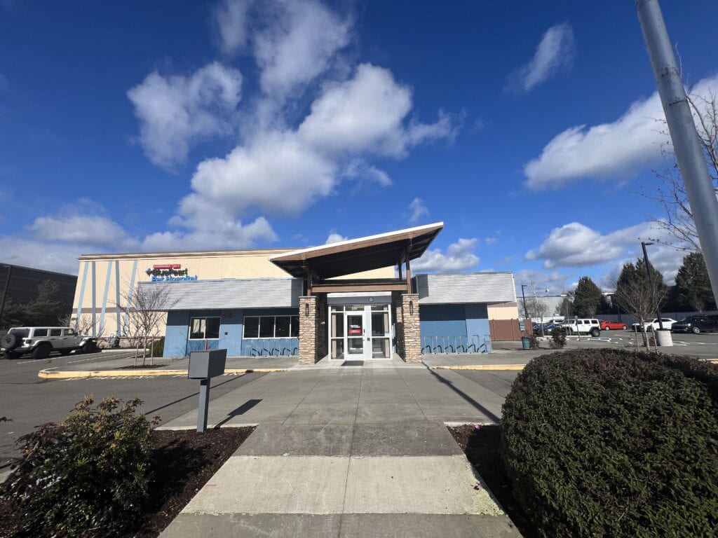 Entrance of BluePearl Pet Hospital with a canopy over glass doors, a sidewalk and a parking lot