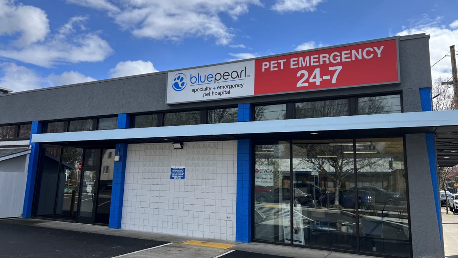 Front of BluePearl Pet Hospital with a red Pet Emergency 24-7 sign above glass doors