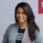 Very small blurry portrait of a smiling woman with long dark hair in a grey cardigan