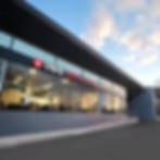 Very blurry low-resolution image of a glass-fronted building at street level under a blue sky