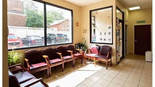 North Shore Animal Hospital waiting room with maroon chairs, a large window and a tiled floor