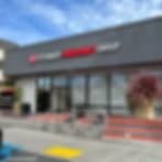 Very blurry photo of a grey storefront with a red sign above a row of windows