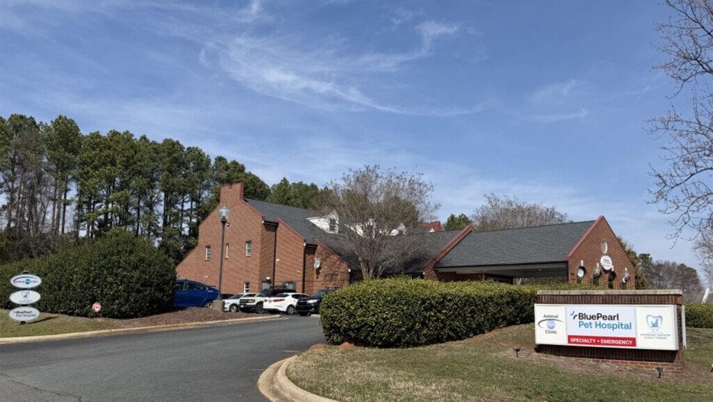 BluePearl Pet Hospital sign in front of a red brick building with trees and blue sky